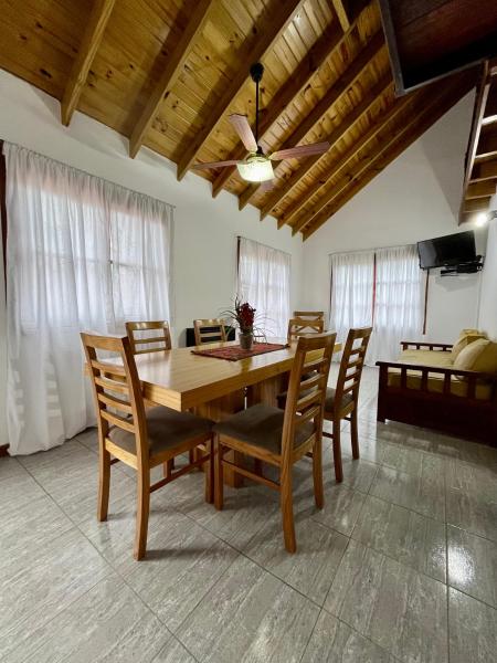 comedor con mesa de madera y sillas en El Horreo Apart en Villa Gesell