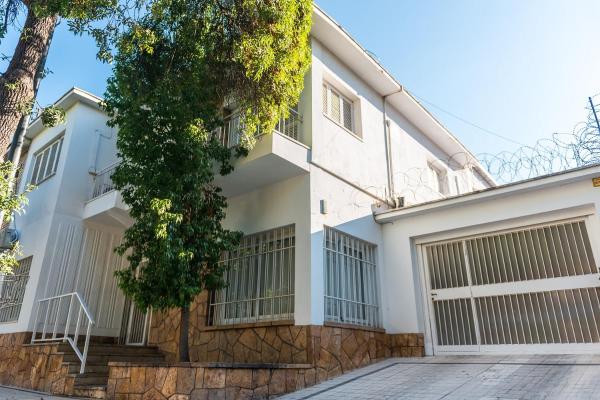 Casa blanca con dos puertas de garaje en Casa Magnolia by Vilvey Turismo en Mendoza