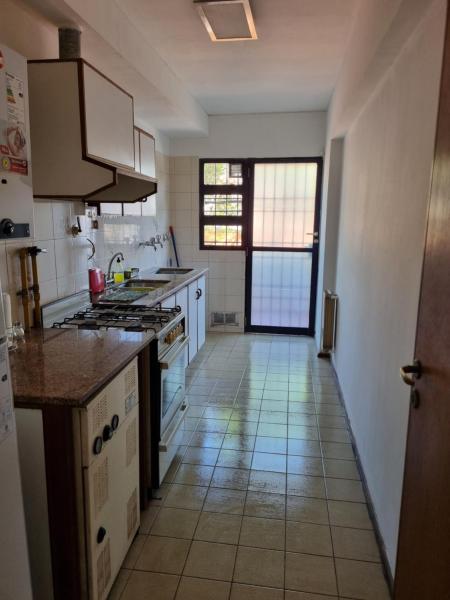 cocina con electrodomésticos blancos y suelo de baldosa. en Departamento excelente ubicación a 4 cuadras calle Aristides Villanueva en Mendoza
