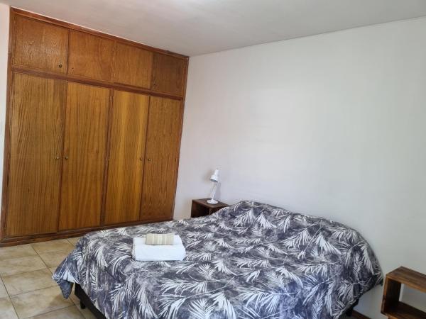 1 dormitorio con 1 cama y armario de madera en Departamento excelente ubicación a 4 cuadras calle Aristides Villanueva en Mendoza