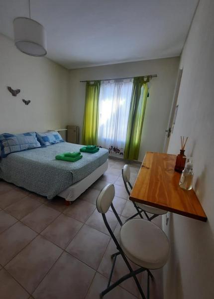 1 dormitorio con 1 cama, mesa y sillas en Franca del mar -casa compartida- en Puerto Madryn
