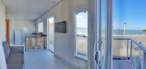 a room with a balcony with a view of the beach at Vista Deslumbrante praia Barra da Lagoa in Florianópolis