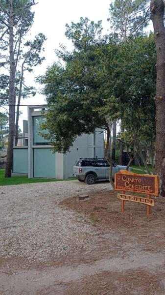 una señal frente a una casa con un coche en Orión en Balneario Mar Azul