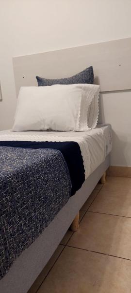 Una cama con dos almohadas encima. en Apartment VICTORIA en Buenos Aires