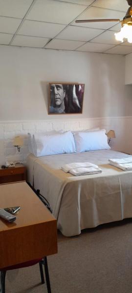1 dormitorio con 1 cama con una foto en la pared en Hotel de Cine Las Golondrinas en Villa Gesell