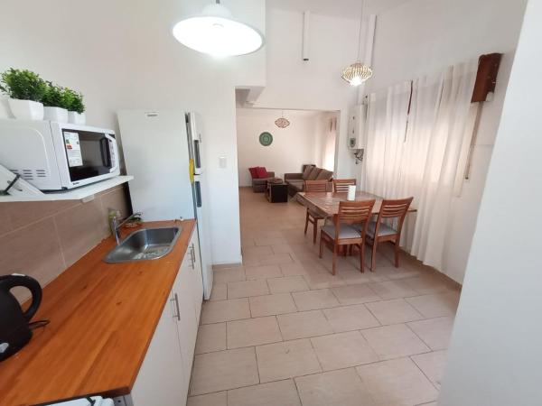 cocina y sala de estar con mesa y sillas en La Casa de Belén en Villa General Belgrano