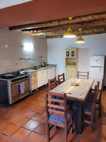 cocina con mesa de madera y fogones en Plaza San Fernando en San Martín de los Andes