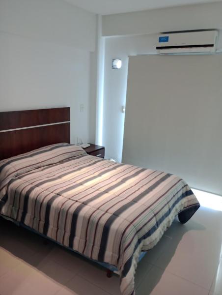 1 dormitorio con 1 cama con manta a rayas en TORRES DEL TUCUMAN en San Miguel de Tucumán