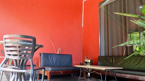 una silla y una mesa en una habitación con una pared roja en Selva mia en Puerto Iguazú