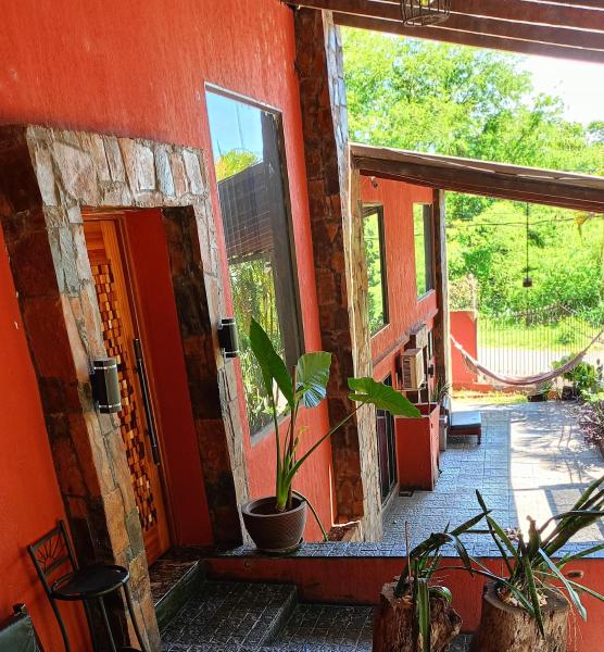 una entrada a una casa roja con una maceta en Selva mia en Puerto Iguazú