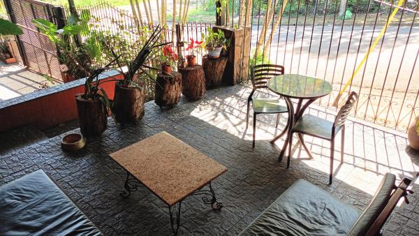 un patio con mesa, sillas y plantas en Selva mia en Puerto Iguazú