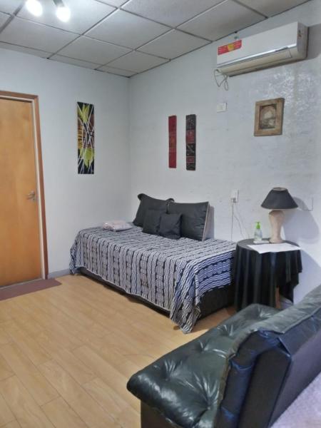 1 dormitorio con cama, mesa y sofá en Departamentos Avenida San Martin en Mendoza