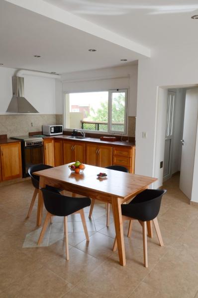 cocina con mesa de madera y sillas en Mara, amplio, luminoso y calido en Puerto Madryn