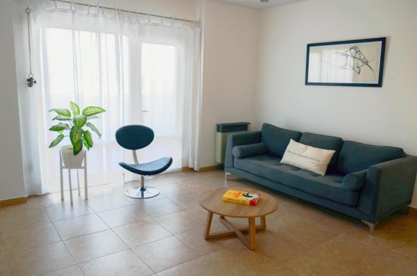 sala de estar con sofá azul y mesa en Mara, amplio, luminoso y calido en Puerto Madryn