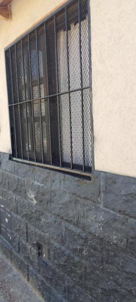 una ventana con barras en el lateral de un edificio en CASA en COSTANERA en Gualeguaychú