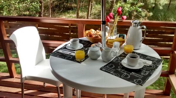 una mesa blanca con desayuno en la terraza en Escondida en el Bosque en Mar de las Pampas