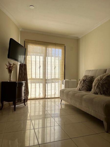 sala de estar con sofá y TV en Departamento luminoso, Capital Mendoza en Mendoza