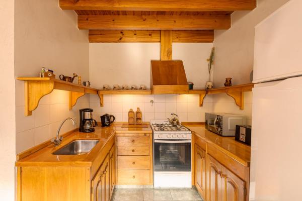 cocina con armarios de madera y horno con fogones en Sol y Nieve en San Martín de los Andes