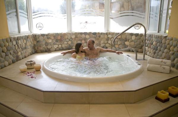 un hombre y una mujer sentados en una bañera en Pillmayken Apart&Spa Mar de las Pampas en Mar de las Pampas