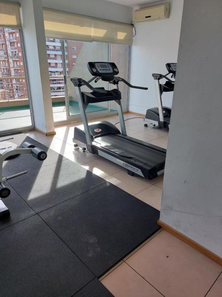 un gimnasio con 3 bicicletas estáticas en una habitación en Excelente Departamento, piso alto en Buenos Aires