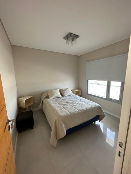 1 dormitorio con cama y ventana en Luminoso depto en Puerto Madryn en Puerto Madryn