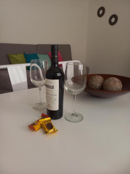 una botella de vino y dos copas de vino en una mesa en La Gema apartamento en Mendoza