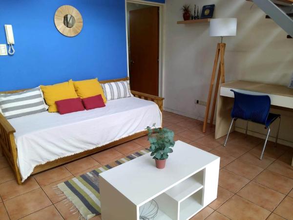Sala de estar con cama y mesa en Duplex dos ambientes con terraza propia y parilla en Buenos Aires