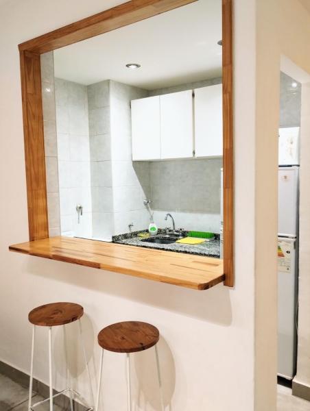 un espejo sobre un mostrador de cocina con dos taburetes en Del sol mdp - departamento en Zona Aldrey en Mar del Plata
