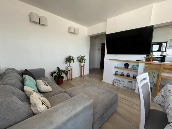 sala de estar con sofá gris y Tv LED en Eleva tus sentidos Hola Sur en Mar del Plata