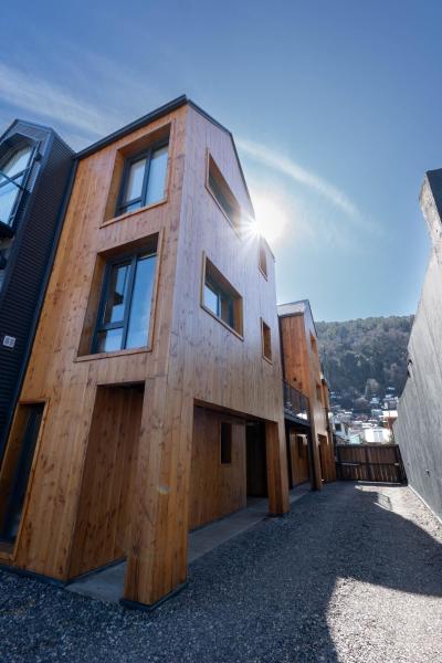 un edificio de madera con el sol en el fondo en Haus del Valle - Nórdica by Skallen en San Martín de los Andes