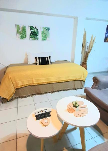 1 dormitorio con 1 cama y 2 mesas en CASA CÉNTRICA, Patio con Parrilla Zona Residencial, Parking privado gratis a 100 mts en Mendoza