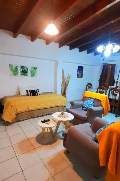 1 dormitorio con cama, sofá y mesa en CASA CÉNTRICA, Patio con Parrilla Zona Residencial, Parking privado gratis a 100 mts en Mendoza
