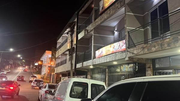 una calle con coches estacionados en el lateral de un edificio en La Familia Hotel en Puerto Iguazú