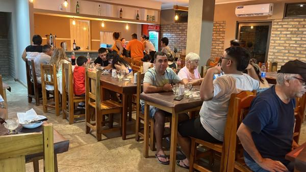 un grupo de personas sentadas en mesas en un restaurante en La Familia Hotel en Puerto Iguazú