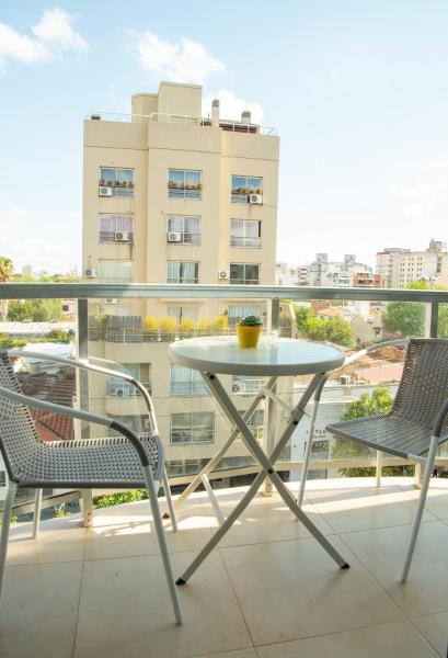una mesa y sillas en un balcón con un edificio en Leguizamon Apart en Salta