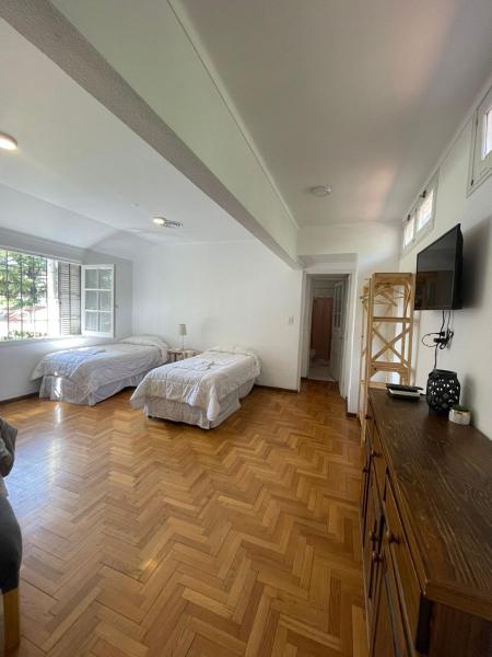 1 dormitorio con 2 camas y suelo de madera en Casabella Bed & Breakfast en Mendoza