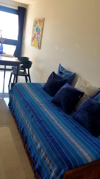 1 dormitorio con cama azul y almohadas azules en Semipiso Casaverde,con doble vista al mar, frente a la playa!con cochera y balcón terraza en Mar del Plata