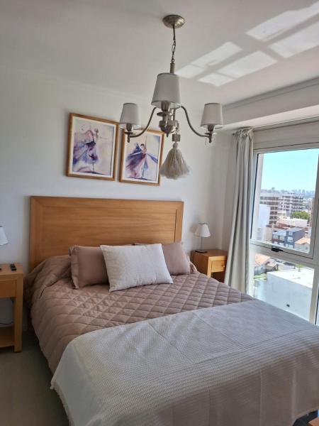 Un dormitorio con una cama grande y una ventana en Edificio Juana del Mar en Mar del Plata