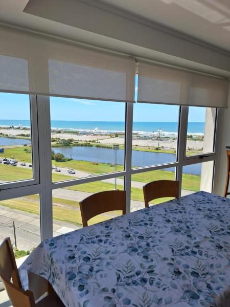 comedor con mesa y vistas al océano en Edificio Juana del Mar en Mar del Plata