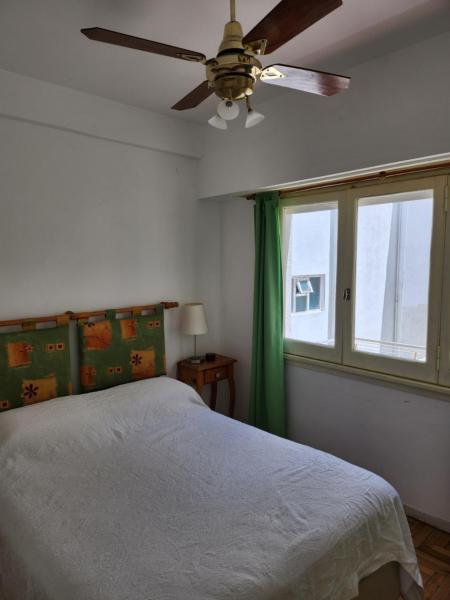 1 dormitorio con 1 cama y ventilador de techo en Departamento Falucho en Mar del Plata