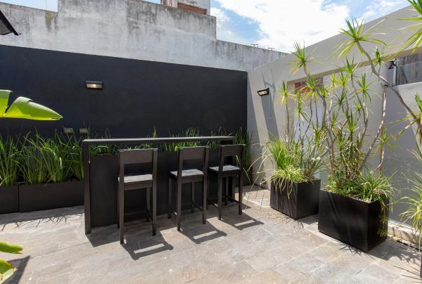 una fila de sillas sentadas junto a una pared con plantas en Modern Luxury Home Perfect for Couples and Families en Buenos Aires
