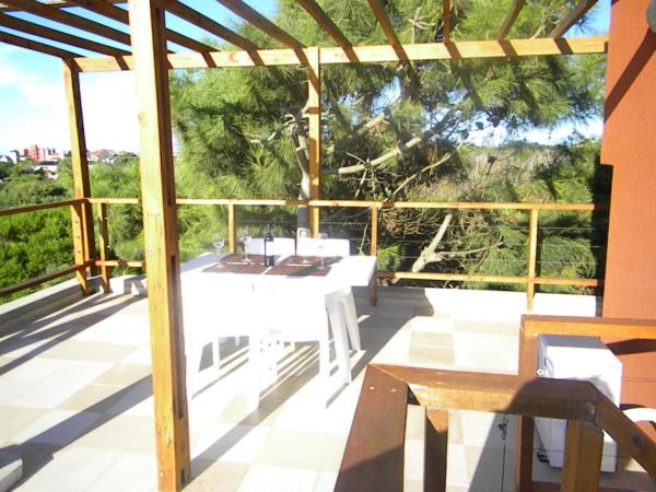 un patio con mesa, sillas y un árbol en Posta Cangrejo Apart en Las Gaviotas