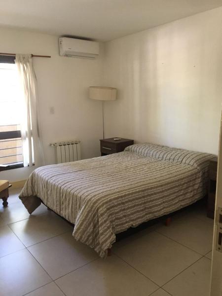 1 dormitorio con 2 camas, lámpara y ventana en Dpto parque central en Mendoza