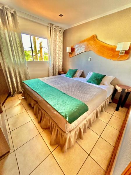 Un dormitorio con una cama grande y una ventana en Tupa hotel iguazu en Puerto Iguazú