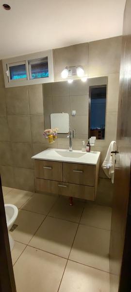 y baño con lavabo y espejo. en Fabulosa y confortable cabaña en Mendoza