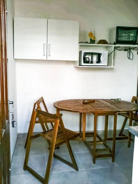 cocina con mesa de madera y microondas en Depto.  completo a metros del mar en Villa Gesell