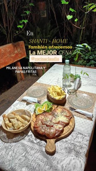 una mesa con un plato de comida y algunas patatas fritas en SHANTI - HOME MAR BLAU en Balneario Mar Blau