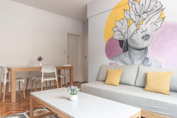 una sala de estar con sofá y una pintura en la pared en Fliphaus Esmeralda 900 - 2 Bd Calle Florida en Buenos Aires