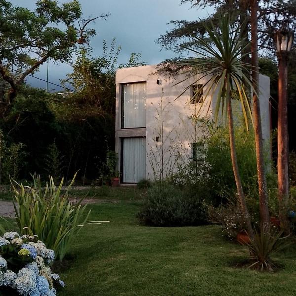 una casa con una palmera en un jardín en Cabaña del Cedro Azul, San Lorenzo en Salta