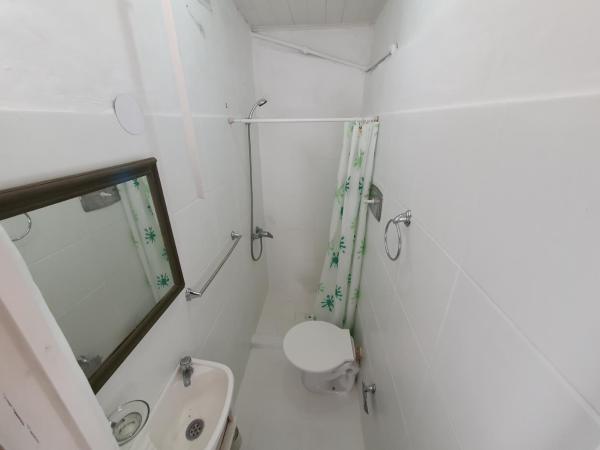 Baño blanco con aseo y espejo en Daireaux en Villa Gesell